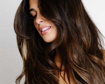 A woman with long, flowing brown hair extensions.